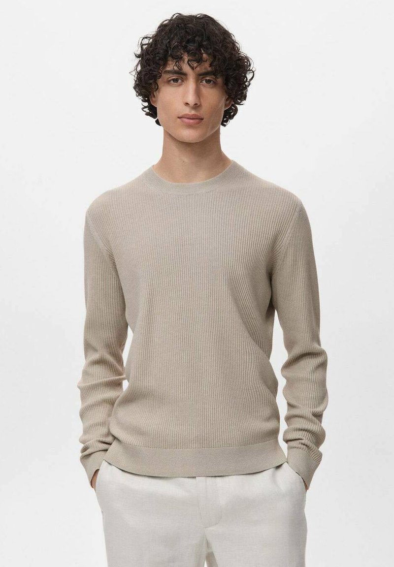 Maglione a coste beige con scollatura rotonda e maniche lunghe. Presenta un punto vita aderente e un motivo testurizzato su tutta la superficie.