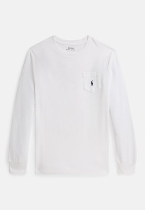 Bela majica z dolgimi rokavi iz bombaža, z žepom na levi strani in majhnim mornarsko modrim logotipom polo na žepu. Prirojen izrez in oprijeti rokavi.