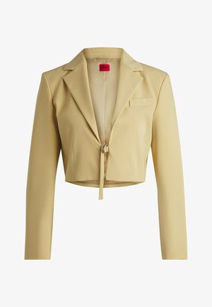 Cropped yellow blazer with long sleeves, notched lapels, and a front closure featuring a metallic ring. Includes a chest pocket.