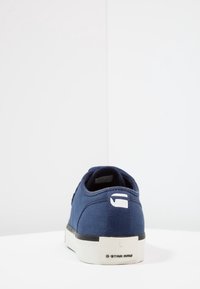 Baskets en toile bleu marine avec une surface texturée, une forme arrondie, une semelle blanche et le logo G-Star RAW au niveau du talon.