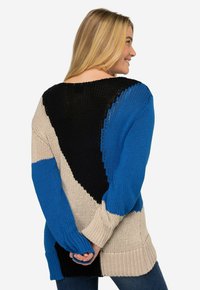 Maglione oversize in maglia con sezioni blu, nero e beige. Tessuto testurizzato con maniche lunghe e orlo a coste. Collo ampio.