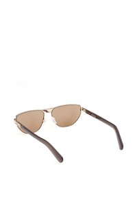 Lunettes de soleil à monture métallique dorée avec des verres teintés marron et des branches en plastique arrondies de couleur brun foncé, vues de dos sur un fond blanc.