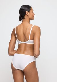 White lingerie set featuring a bra with adjustable straps and a matching brief. Smooth texture with minimalistic design and no visible patterns.