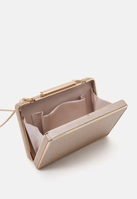 Pieni suorakulmainen metallinhohtoinen kultainen clutch-laukku, jossa on ketjuhihna, auki, näyttäen beigeä kangasvuorta, jossa on useita osastoja.