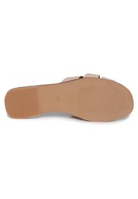 Open-toe, hak sandaal met een gladde, tan kleurige zool. Beschikt over twee brede, platte banden met een lichte glans en een geprofileerde, rubberen onderkant voor grip.