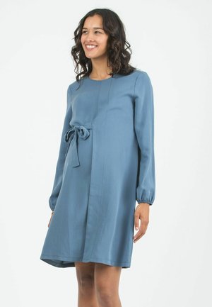 Abito premaman blu, lunghezza al ginocchio, con maniche lunghe, collo rotondo e dettaglio a fiocco frontale in vita, realizzato in tessuto morbido.