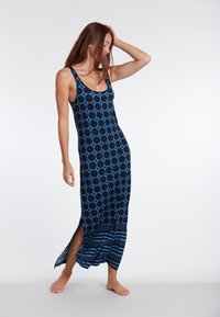 Sininen ja laivastonsininen olkaimeton maxi-mekko, jossa on pyöreä kuvio, sivurei'itykset ja raidallinen helma. Pehmeä, kevyt kangas.