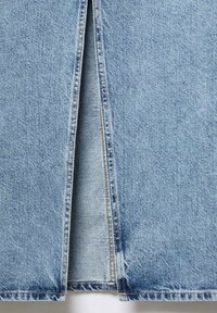 Vaaleansininen farkkuhame, jossa on edessä halkio, suorat saumat ja kontrastivärinen ompelu, joka esittelee tekstuurimateriaalia.