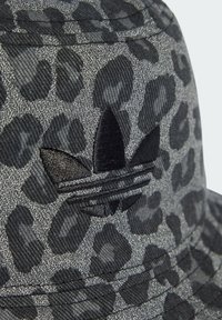 Black and gray bucket hat with a leopard print design. Features a textured fabric and an embroidered black Adidas logo on the side.