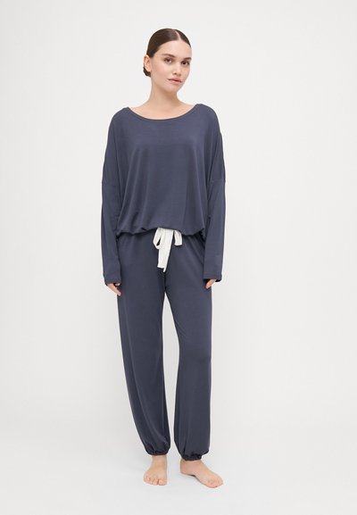 Dark gray lounge set featuring a loose-fit long-sleeve top with a round neckline and a matching pair of tapered pants with elastic cuffs.