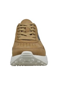 Helle Wildledersneaker mit beigen Schnürsenkeln, perforiertem Zehenbereich und dicke, strukturierte weiße Gummisohle, von vorne betrachtet.