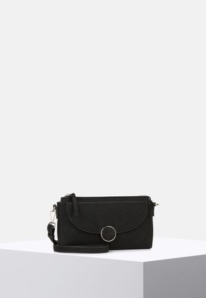 Sac bandoulière rectangulaire noir avec rabat avant, fermoir rond en argent et bracelet détachable, présenté sur un socle blanc.