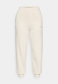 Helle, cremefarbene Jogginghose aus weichem Material mit einem elastischen Bund, schmal zulaufenden Bündchen und einem kleinen Logo-Akzent in Hellblau.