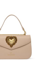 Borsa in pelle beige con una chiusura a forma di cuore dorato decorata con abbellimenti. Presenta una maniglia superiore e una catena decorativa dorata.