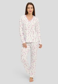 Conjunto de pijama floral en blanco, con flores rosas, manga larga y encaje en el escote. Tela suave y diseño de corte holgado.