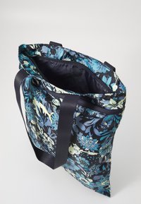 Navy floral tote bag with blue and green patterns, fabric material, two handles, and a zippered top opening. Interior features a plain lining.