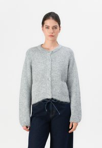 Grijze gebreide cardigan met een ronde halslijn, knoopsluiting aan de voorkant en een zachte textuur. Beschikt over een zak en een trekkoorddetail aan de zoom.