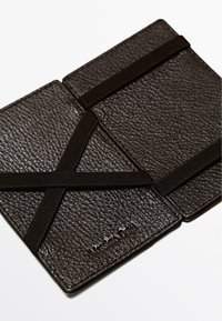 Portafoglio organizer in pelle marrone scuro con superficie testurizzata, dotato di elastici per la chiusura e dettaglio logo in rilievo.