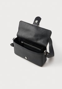 Borsa a spalla in pelle nera con texture, patta aperta, chiusura a bottone a pressione argentato e tasca interna con zip su sfondo bianco.