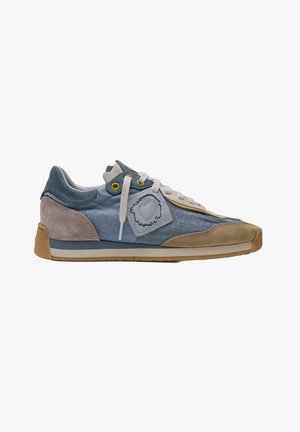 Zapatilla informal con tela azul, detalles en ante beige y marrón, cordones de color blanco roto, ojetes amarillos y un parche cosido en el lateral.