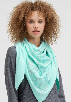 Mint green triangular scarf made of soft fabric featuring silver printed letters and musical notes, worn over a dark gray sweater.