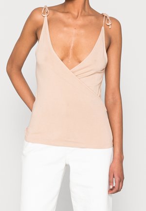 Ärmelloses Top in hellem Beige, aus weichem Stoff, mit tiefem V-Ausschnitt und Wickeldesign mit verstellbaren Bindeträgern. Flache Nähte.