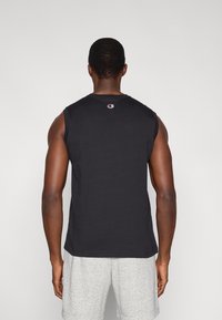 Μαύρο αμάνικο μπλουζάκι με στρογγυλή λαιμόκοψη, με μικρό κεντητό λογότυπο στο πίσω μέρος. Μαλακό βαμβακερό ύφασμα και άνετη εφαρμογή.