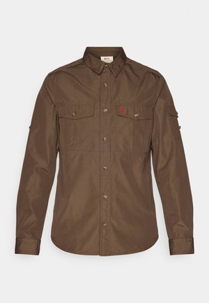 Brown long-sleeve shirt made of fabric with a smooth texture. Features two chest pockets, a button-up front, and a logo on the left side.
