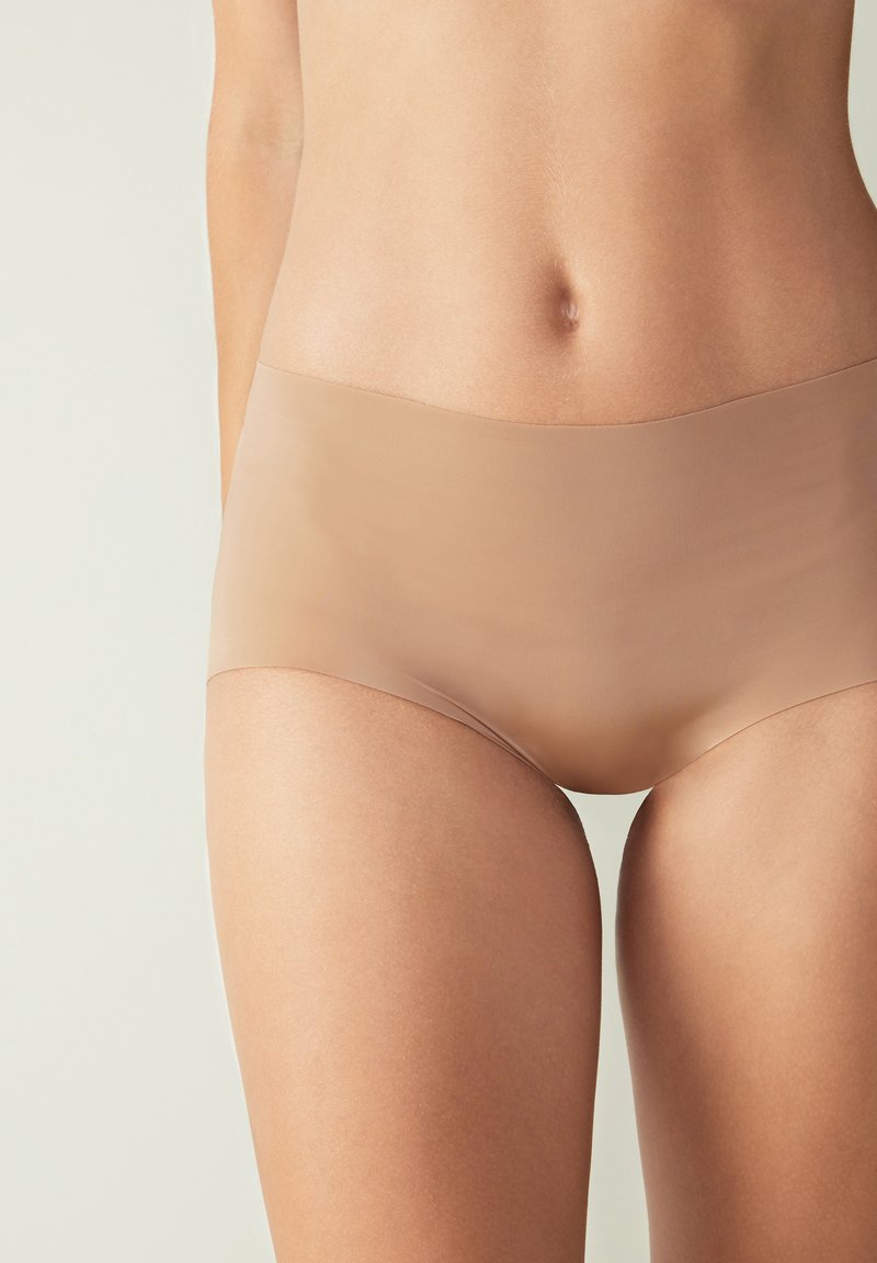 Beige bezešvé hipster spodní prádlo s hladkým, elastickým materiálem. Nabízí plné pokrytí a minimalistický design bez viditelných švů.