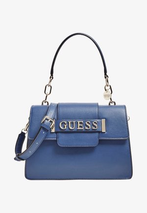 Blauwe leren handtas met bovenhandvat en verstelbare riem, met zilverkleurige hardware en het "GUESS"-logo op de voorflap.
