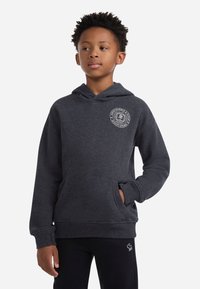 Felpa con cappuccio grigio scuro, dotata di tasca anteriore e polsini a coste, caratterizzata da un logo circolare stampato sul lato sinistro del petto. Texture morbida.