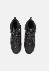 Schwarze Wanderschuhe mit gepolstertem Schaft, synthetischem Obermaterial und schwarz-weißen Schnürsenkeln. Mit einem Zugriegel an der Rückseite für ein einfaches Anziehen.