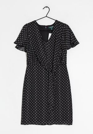 Robe noire à pois blancs, décolleté en V, manches courtes à volants, design croisé avec un lien à la taille, tissu texturé léger.