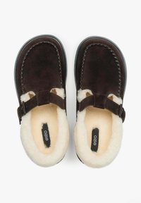 Hnědé semišové nazouvací boty s měkkým krémovým kožíškem uvnitř, otevřená špička a nastavitelný pásek. Plochá gumová podrážka, šité detaily.