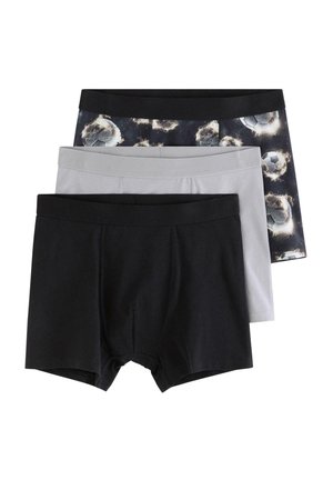 Kolme paria miesten bokserialushousuja päällekkäin: yksiväriset mustat, yksiväriset harmaat ja mustat, joissa hohtava jalkapallokuvio.