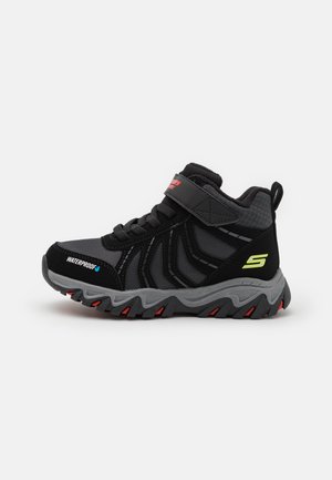 Sapatos atléticos à prova d'água em preto, com um superior texturizado, acentos cinzentos e um fecho de tiras seguro. Apresenta uma sola durável com tração vermelha.