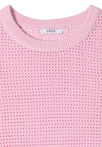 Pull rose en maille avec encolure ronde côtelée et texture tissée, avec une étiquette blanche portant le nom de la marque « CECIL » à l'intérieur du col.