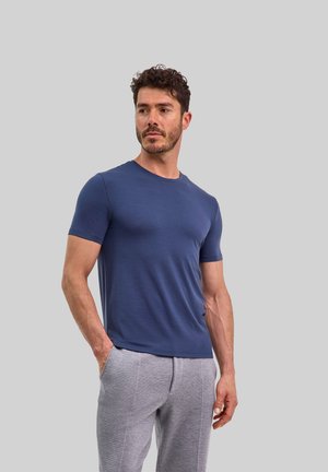 Navyblauw T-shirt met korte mouwen en een ronde hals, gladde textuur, gecombineerd met lichtgrijze sweatpants met zijzakken en een rechte snit.