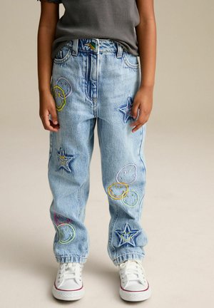 Jean en denim bleu clair avec des sourires colorés brodés et des étoiles sur le devant. Dispose d'un design classique à jambes droites et de poignets à revers.