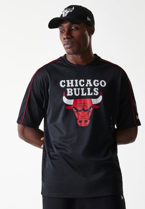 Juodas tinklinis džersis su raudonais akcentais ir "CHICAGO BULLS" tekstu. Priekyje yra buliuko grafika. Dėvimas su atitinkama juoda kepure.