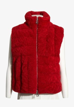 Chaleco sin mangas rojo y peludo con cuello alto y cremallera frontal, mostrado en un torso de maniquí blanco sobre un fondo blanco.