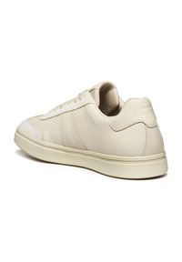 Sneaker beige chiaro con dettagli in pelle e camoscio, punta rotonda, suola piatta in gomma, accenti testurizzati e logo discreto sul tallone.