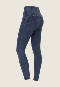 Matalavartiset denim leggings tummansinisinä, joissa on nauhakiinnitys takana, slim fit -malli ja sileä pinta, sekä kaarevat takataskut.