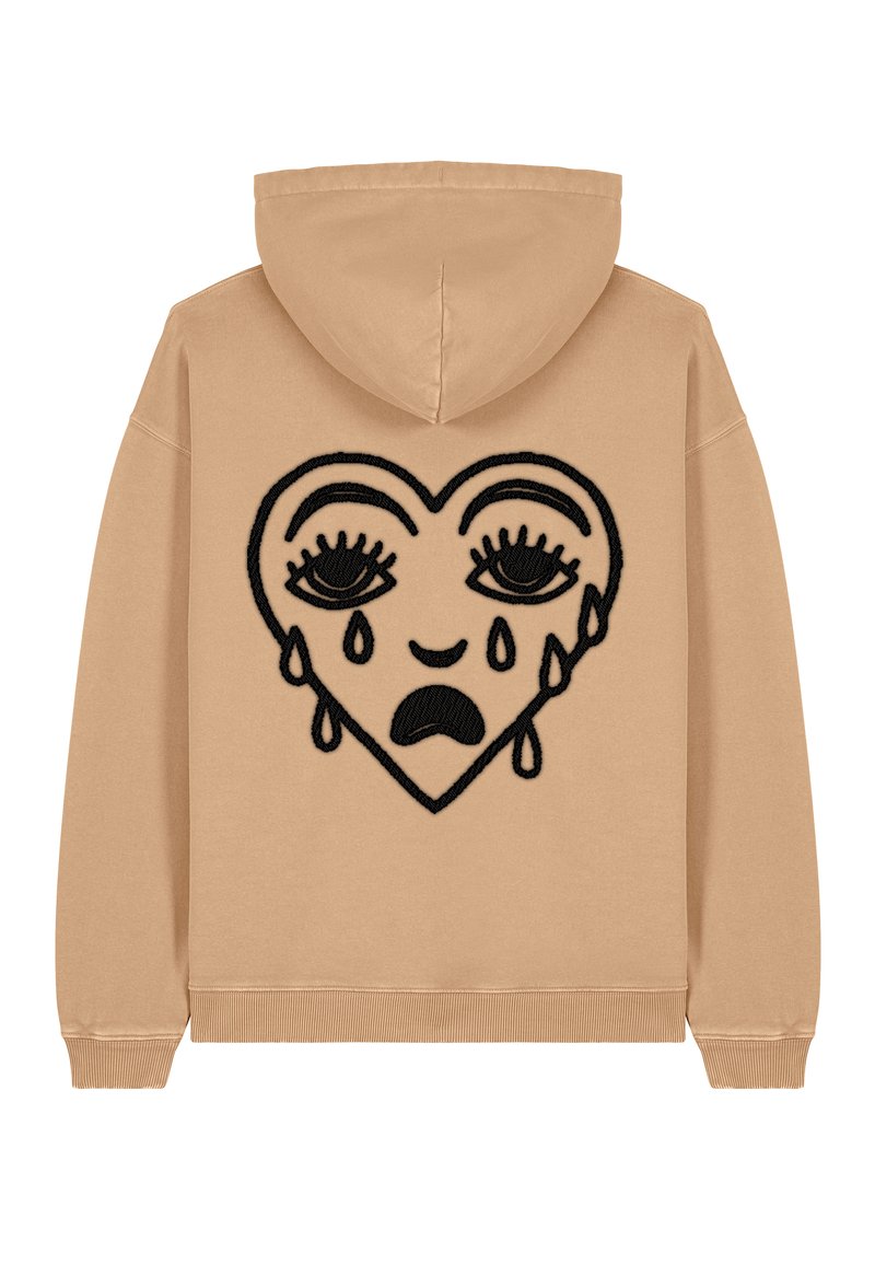 Felpa beige con un grande design di cuore ricamato nero, dotato di occhi e dettagli a lacrima, realizzata in tessuto morbido con polsini e orlo a costine.
