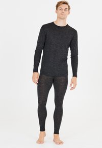 Zwart long sleeve shirt en leggings set gemaakt van een zachte, gestructureerde stof. Aansluitend ontwerp met minimale naden, beide tonen een gemêleerd patroon.