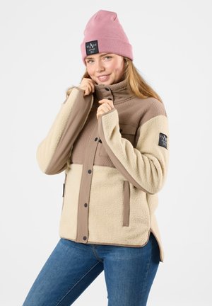Fleecejack in beige en bruin met een rits en drukknoopsluiting, voorzien van twee voorzakken en een gewatteerde kraag. Draagt een roze beanie.