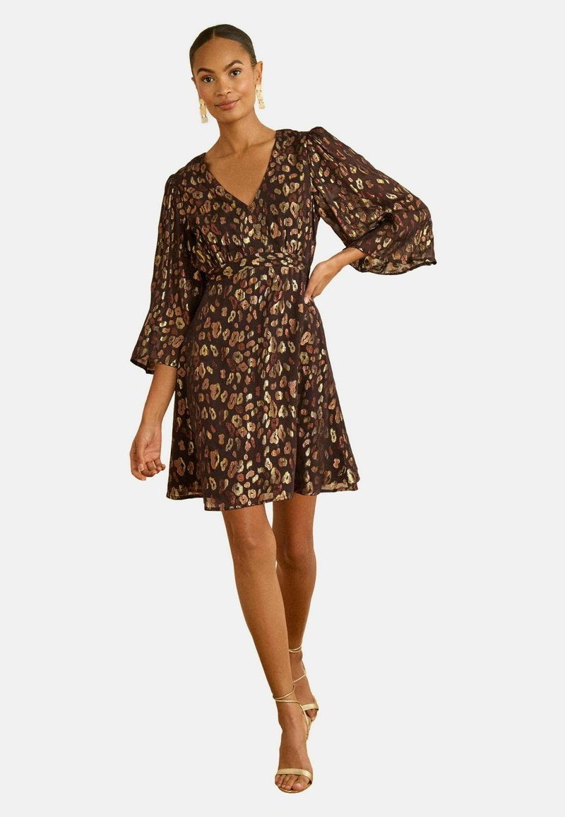 Rochie maro cu model, decolteu în V, mâneci lungi bufante, talie strânsă și fustă evazată. Accentuate cu imprimeuri leopard auriu și crem.