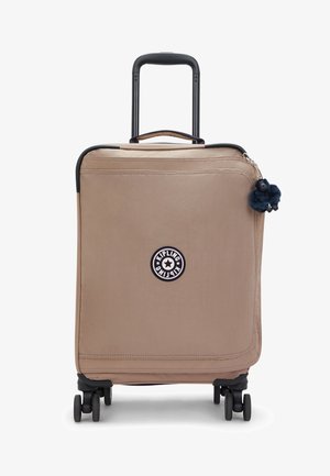 Valigia a mano con ruote in tessuto beige morbido con componenti nere, caratterizzata da un logo circolare e un ciondolo per cerniera peloso blu. Quattro ruote girevoli.