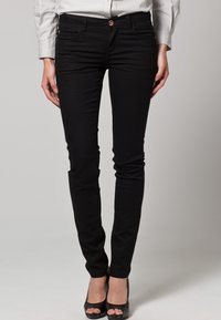Svarta slim fit-jeans med en slät yta, med en knappstängning och två framfickor. Designade för att sitta tätt genom benet.