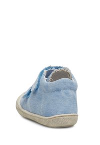Scarpa di tela azzurro chiaro con bordi sfrangiati, tacco arrotondato e suola in gomma bianca, che mostra una superficie texture e un design casual.
